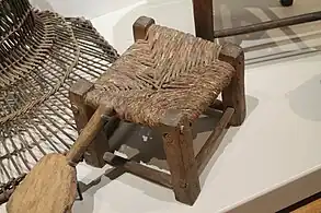 Escabel o taburete antiguo fabricado con madera y enea