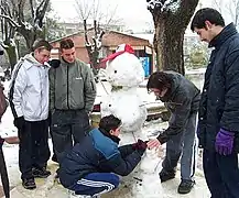 Hombres modelando un muñeco de nieve