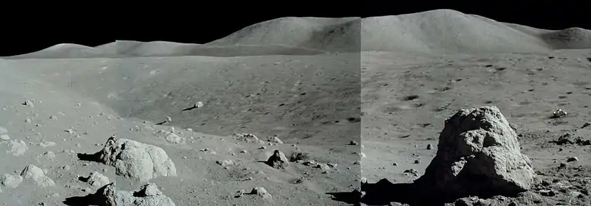 Cráter Nansen en la base del Macizo Sur, mirando hacia el norte. Obsérvese el róver al fondo, cerca del borde derecho de la imagen. La roca en el primer plano a la derecha fue analizada por los astronautas.