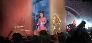 Four band members perform before a live audience