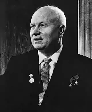 An elderly man in a suit, with three medals pinned on it