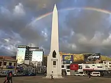 Foto del obelisco del centro de Ibarra con un arcoíris en el fondo.