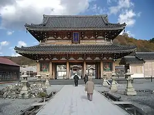 La puerta de entrada del templo Bodai-ji en el monte. A los lados del camino se aprecian riachuelos de agua amarillenta por el azufre.