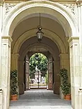 La puerta de la Glorieta y la estatua del Cardenal Belluga desde el patio.