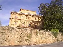 Vista de la fachada este con el escudo heráldico de la familia del fundador.