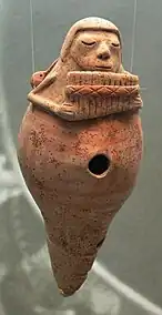 Pito de barro con un músico soplando una flauta de pan, cultura Jama Coaque (300 a. C. - 700 d. C.), costa del Ecuador. Colección Ebnöther, Museo Allerheiligen, Schaffhausen, Suiza.