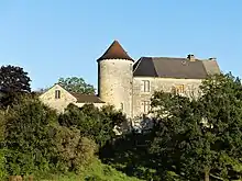 VIsta del castillo de la Faurie. Se ve tras unos árboles, en buen estado y con aspecto de usarse como vivienda