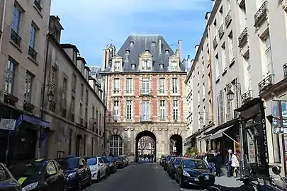 Vista del Pavillon du Roi desde la rue de Birague, la fachada lleva el monograma de Henri IV y el pasaje permite la comunicación con la place des Vosges .