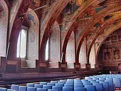 Los escaños del siglo XVI recorren todo el perímetro de la sala