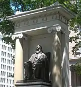 El monumento a Peter Cooper se encuentra entre el edificio de la Fundación y el parque Cooper Triangle