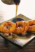 Picarones peruanos siendo bañados con miel de chancaca