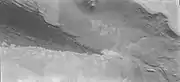 El borde de las dunas oscuras de Abalos Undae se muestra justo debajo de la escarpa y el casquete polar.