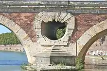 El puente está equipado con crestas frente a cada pilar para separar los flujos y aberturas que permiten que el agua pase incluso cuando alcanza la parte superior de los arcos.