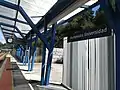 Letrero de la estación, reloj y panel electrónico de información