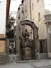 Arco con estatua barroca, junto al Palacio Diamant