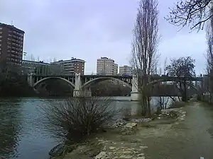 Vista del Puente del Poniente (o de Francisco González Regueral) sobre el río Pisuerga en Valladolid, desde la orilla izquierda del río, bajo la Rosaleda Francisco Sabadell