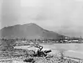 Apia y la playa cubierta de madera a la deriva y escombros de los buques de guerra naufragados.