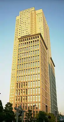 Ground-level view of a boxy, gray high-rise