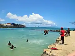 Niños zambulléndose en el mar desde el muelle