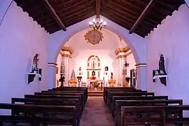 Vista de la nave de la iglesia parroquial de Sesga (Ademuz), con detalle del arco de diafragma, el presbiterio al fondo (2017.