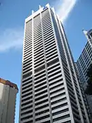 Ground-level view of a 50-storey white tower with a rectangular cross section and dark windows