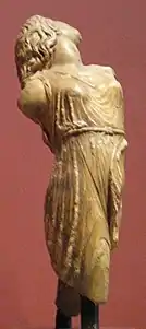 Figura femenina de una ménade en un rito dionisiaco. La escultura representa la torsión del cuerpo al bailar; imita la técnica de los paños mojados, aunque la mujer tiene un pecho y el muslo al descubierto debido al movimiento frenético. Llama también la atención que aparece con el pelo suelto y le faltan las extremidades. Teóricamente esta ménade llevaría un cabritillo o un cordero en los hombros para ser sacrificado.