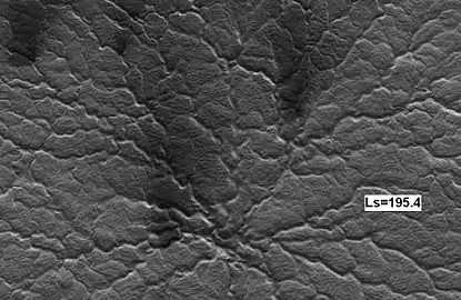 La misma araña 14 días marcianos después, vista por HiRISE. Observe el aumento de ventiladores oscuros causado por la desgasificación del dióxido de carbono que transporta material oscuro.