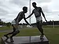 Escultura de Mitch Mitchell que muestra un momento de deportivismo en el estadio.