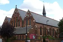 Iglesia de St Thomas (1888-1889), Islington, Londres, vista de la fachada occidental y de la nave lateral sur mostrando lancetas y el narthex de estilo inglés temprano debajo de las ventanas del oeste