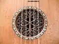 La boca de una guitarra barroca con una roseta tallada en madera e insertada (1700).