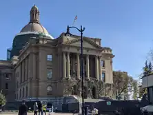 Un alto edificio gubernamental con enredaderas que cuelgan de la fachada.