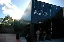 Un edificio negro futurista de estilo monolítico que alberga la Exposición Oficial de Matrix.