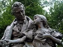 Bronze statue of a seated man with a young girl beside him