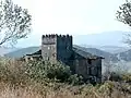 Torre de planta cuadrada terminada con almenas.