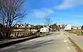 Paisaje urbano en Torrebaja (Valencia), detalle del puente sobre el río Ebrón en la avenida de la Diputación, con el caserío al fondo (2021).