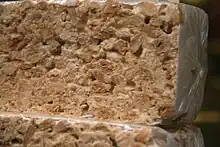 Detalle de un ejemplar de pastilla de turrón de Alicante, el que puede verse la abundancia de almendras empleada en su masa.