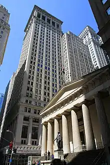 El Federal Hall, antigua Aduana de los Estados Unidos, actualmente un museo, con las torres de Wall Street detrás de él.