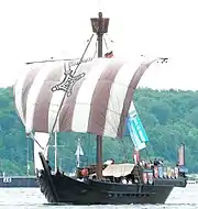 Colour photograph of a small medieval-era single-masted sailing ship