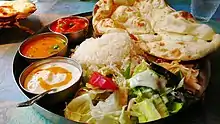 Awadhi thali (plato) con pan Naan, Daal, Raita, Shahi paneer y Ensalada .