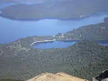 Vista del Lago Correntoso (delante) y el Lago Nahuel Huapi (atrás) desde el Cerro Bayo. En el centro de la imagen se ve el nacimiento del Río Correntoso (y el puente que lo cruza), pudiéndose apreciar su corta longitud.