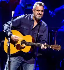 El cantante de música country Vince Gill, rasgueando una guitarra acústica