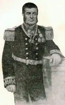 Gravado, retrato de três quartos de comprimento de um homem com cabelo escuro e costeletas encostado a um plinto e vestido com um uniforme naval elaboradamente bordado com uma túnica trespassado adornados com dragonas e medalhas