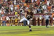 El jugador de fútbol americano Wes Schweitzer celebra un touchdown arrojando el balón al suelo.