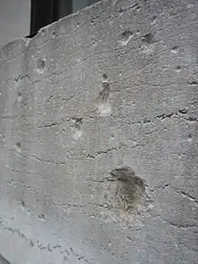 Photograph of damage to a wall of 23 Wall Street from the 1920 Wall Street Bombing.