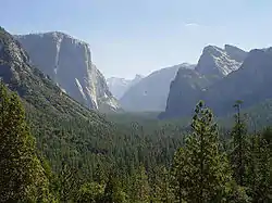 Vista del valle de Yosemite (California), valle glaciar «en U» surcreusée en el Cuaternario: paredes de rocas cristalinas intrusivas cretácicas de varios cientos de metros que dominan el fondo granítico del valle.