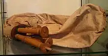 A simple bagpipe made of cloth with two wooden mouthpieces.