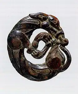 Adorno de arnés en forma de lobo enroscado, característico de los artefactos nómadas del sur de Ningxia y sudeste del Gansu, s.V-IV AEC[16]​[14]​