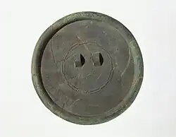 Espejo de bronce con una decoración lineal en relieve muy fino, que incluye motivos de «estrella radiante» y friso de tiras «positivas-negativas». Sitio de Daegok.[15]​[16]​