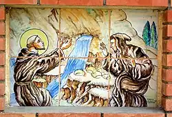 Plafón cerámico representando a san Francisco de Asís a la entrada del Vía Crucis de Casas Altas (Valencia), siglo XX