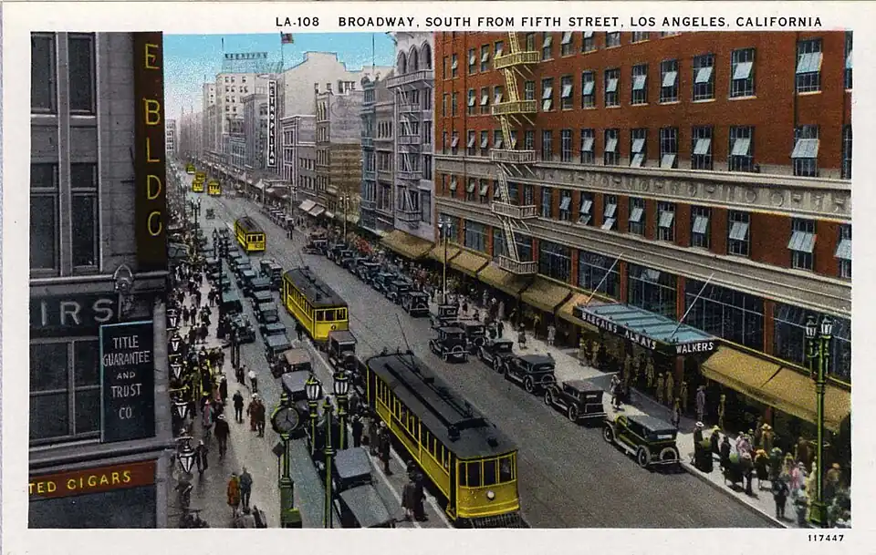 Tarjeta postal con vista de la calle Broadway en 1927, cuando era la zona de compras más importante de Los Ángeles. Se ven los grandes almacenes de Walker's y los tranvías urbanos amarillos del Los Angeles Railway.